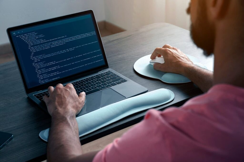 Rear view of man working on laptop