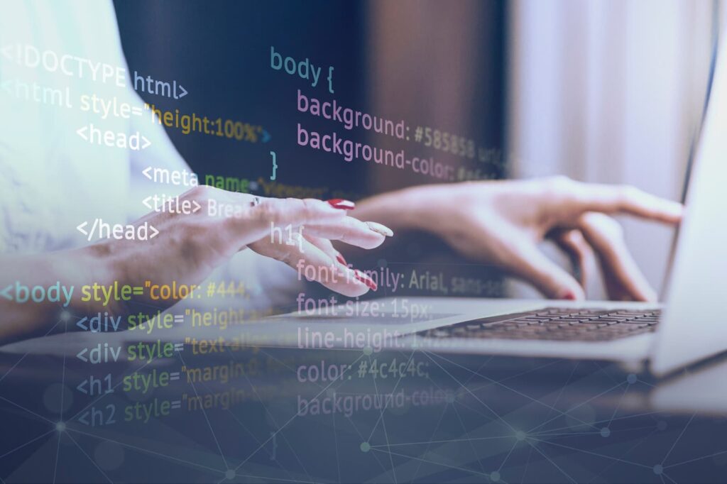 Woman's hands on laptop keyboard with software code